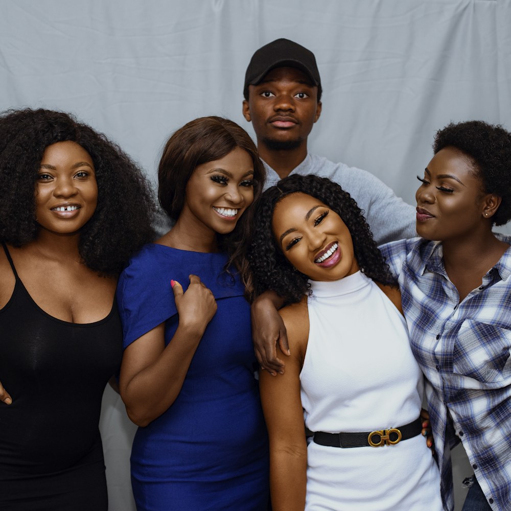 Group of friends laughing on a grey backdrop
