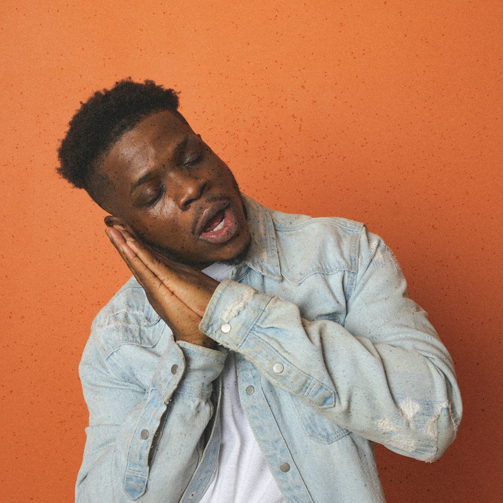 Man laughing on an orange backdrop
