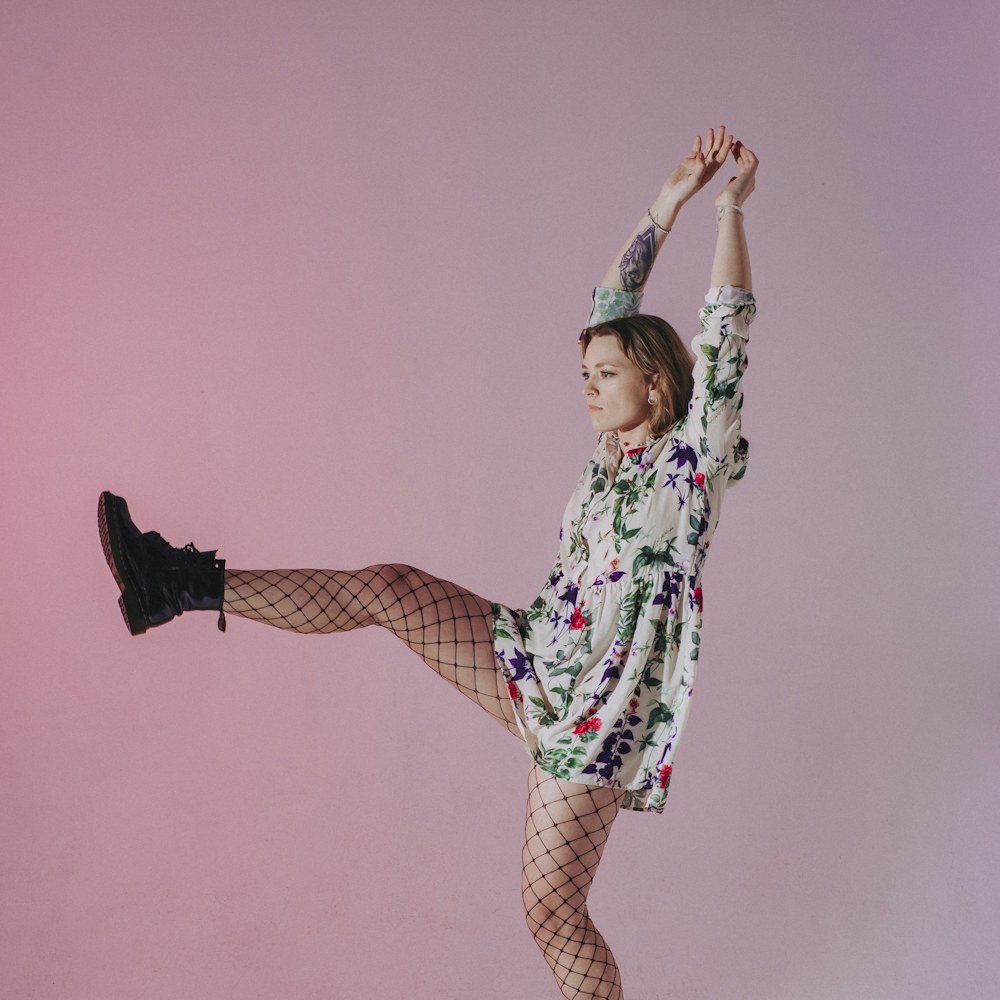 Woman dancing on a pink backdrop